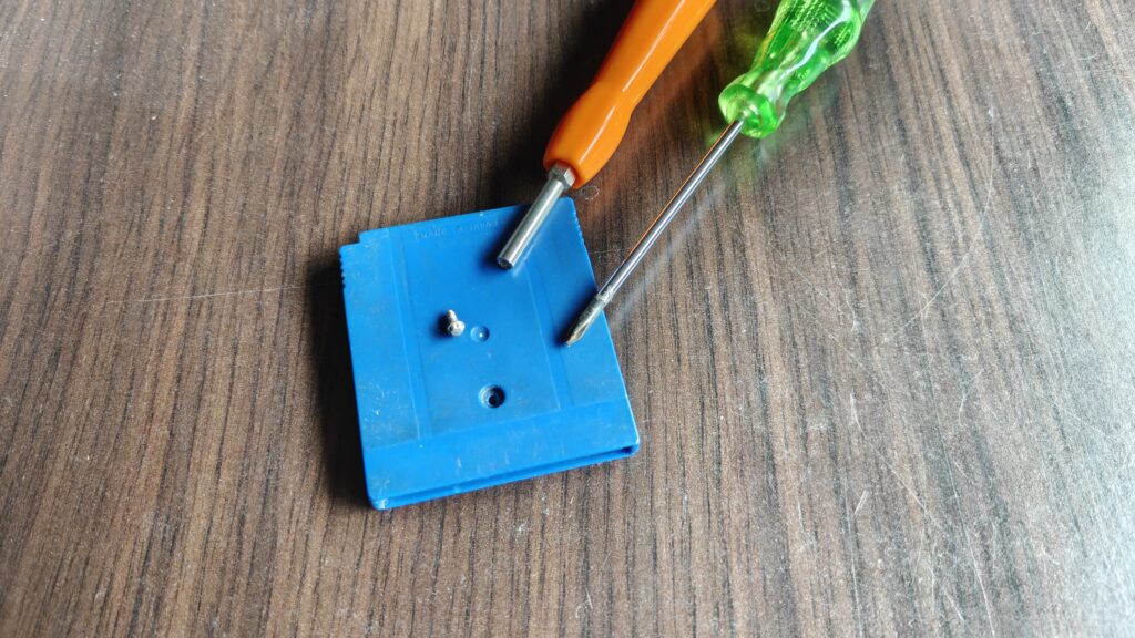 de 3,8 mm schroef ligt naast zijn eigen gat. Het gereedschap met de holle punt is de gamebit, de kruiskop past er niet in.
